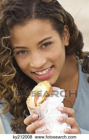 Portrait of a girl holding a sandwich and smiling View Large Photo Image Stock Photo - Portrait of a girl holding a sandwich and smiling. Fotosearch
