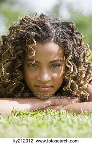 Portrait of a girl lying on grass View Large Photo Image Stock Image - Portrait of a girl lying on grass. Fotosearch