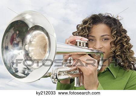 Portrait of a girl playing a trumpet View Large Photo Image Stock Image - Portrait of a girl playing a trumpet. Fotosearch