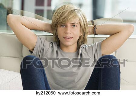 Portrait of a teenage boy sitting on the bed View Large Photo Image Stock Image - Portrait of a teenage boy sitting on the bed. Fotosearch
