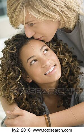 Stock Photograph - Teenage boy kissing on the forehead of a girl. Fotosearch
