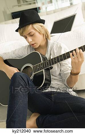Teenage boy playing a guitar View Large Photo Image Stock Image - Teenage boy playing a guitar. Fotosearch
