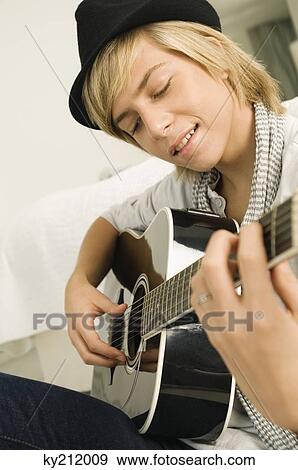 Teenage boy playing a guitar View Large Photo Image Stock Photo - Teenage boy playing a guitar. Fotosearch