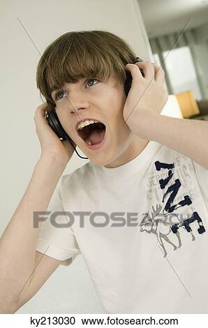Stock Image - Boy listening to headphones and shouting. Fotosearch