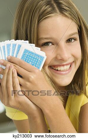Stock Image - Girl holding playing cards. Fotosearch
