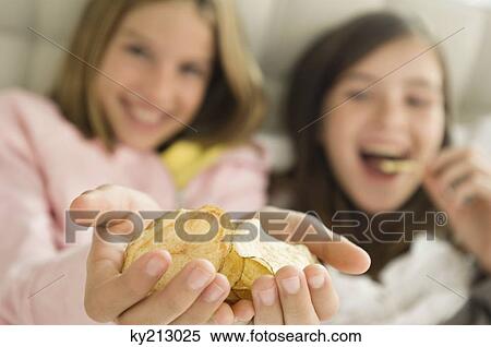 Girl holding potato chips in her hands View Large Photo Image Stock Photography - Girl holding potato chips in her hands. Fotosearch