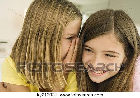 Girl whispering to her sister View Large Photo Image Stock Image - Girl whispering to her sister. Fotosearch