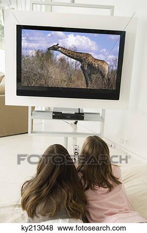 Stock Photo - Rear view of two girls watching television. Fotosearch