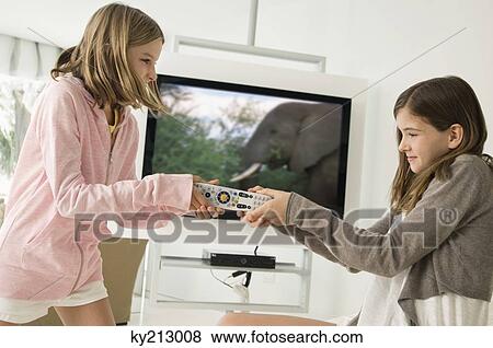 Two girls fighting for a remote control View Large Photo Image Stock Photo - Two girls fighting for a remote control. Fotosearch