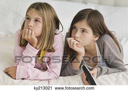 Two girls watching television View Large Photo Image Stock Image - Two girls watching television. Fotosearch