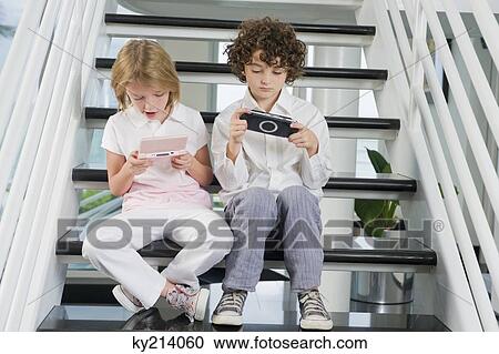 Boy and a girl playing video game View Large Photo Image Stock Image - Boy and a girl playing video game. Fotosearch