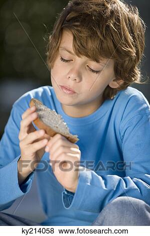 Boy eating a slice of bread View Large Photo Image Stock Photo - Boy eating a slice of bread. Fotosearch