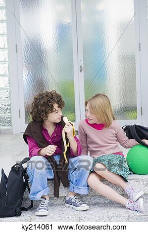 Brother eating a banana and sitting with his sister on steps View Large Photo Image Stock Image - Brother eating a banana and sitting with his sister on steps. Fotosearch