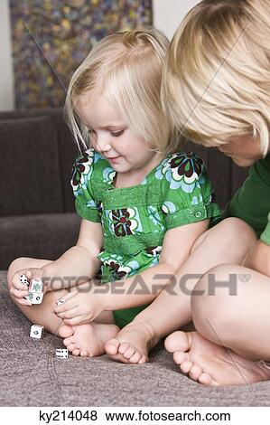 Girl playing dices with her brother View Large Photo Image Stock Photo - Girl playing dices with her brother. Fotosearch