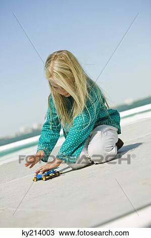 Girl playing with a remote controlled car View Large Photo Image Stock Image - Girl playing with a remote controlled car. Fotosearch