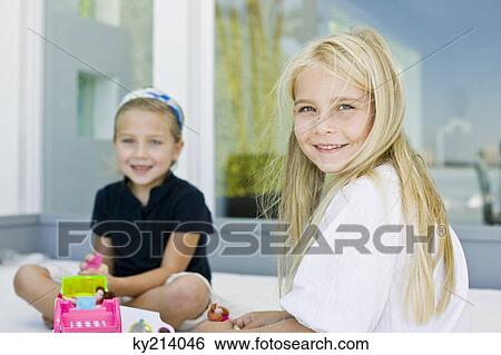 Portrait of two girls playing with toys View Large Photo Image Stock Photograph - Portrait of two girls playing with toys. Fotosearch