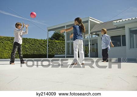Stock Photo - Three children playing with a ball. Fotosearch