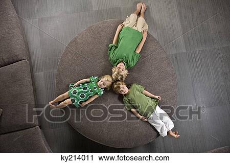 Three friends lying on a round sofa View Large Photo Image Stock Image - Three friends lying on a round sofa. Fotosearch