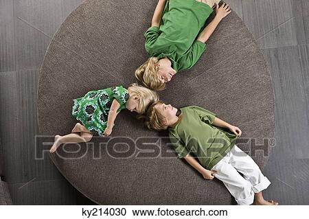 Three friends lying on a round sofa View Large Photo Image Stock Image - Three friends lying on a round sofa. Fotosearch
