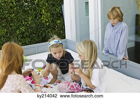 Three girls playing with toys and a boy looking at them View Large Photo Image Stock Image - Three girls playing with toys and a boy looking at them. Fotosearch