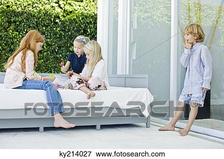 Three girls playing with toys and a boy looking at them View Large Photo Image Stock Photo - Three girls playing with toys and a boy looking at them. Fotosearch