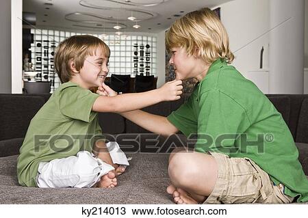Two boys touching each other's chin and smiling View Large Photo Image Stock Image - Two boys touching each other's chin and smiling. Fotosearch