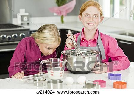Two girls cooking food in the kitchen View Large Photo Image Picture - Two girls cooking food in the kitchen. Fotosearch