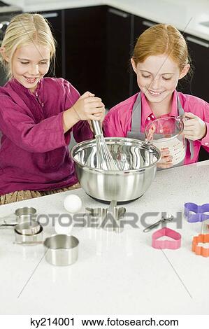 Two girls cooking food in the kitchen View Large Photo Image Stock Image - Two girls cooking food in the kitchen. Fotosearch