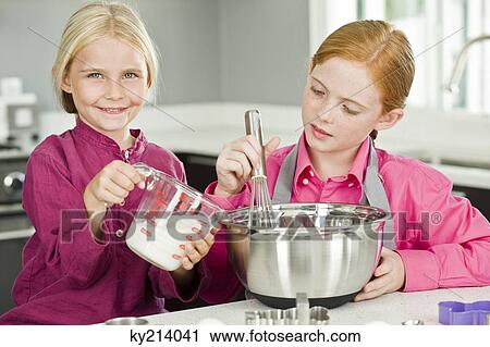 Two girls cooking food in the kitchen View Large Photo Image Stock Image - Two girls cooking food in the kitchen. Fotosearch
