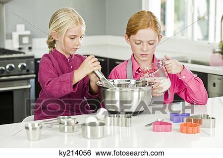 Two girls cooking food in the kitchen View Large Photo Image Stock Photograph - Two girls cooking food in the kitchen. Fotosearch