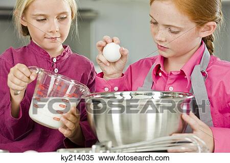 Two girls cooking food in the kitchen View Large Photo Image Stock Photography - Two girls cooking food in the kitchen. Fotosearch