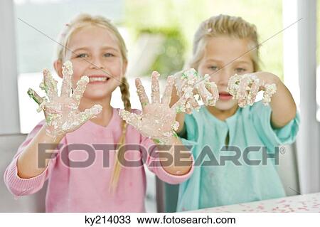 Two girls showing her hands covered with cake icing View Large Photo Image Stock Image - Two girls showing her hands covered with cake icing. Fotosearch