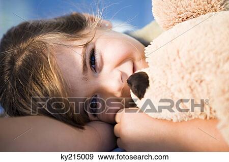 Girl cuddling teddy bear View Large Photo Image Stock Photo - Girl cuddling teddy bear. Fotosearch