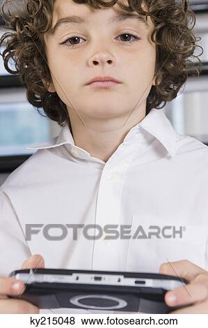 Stock Photo - Portrait of a boy holding a video game. Fotosearch