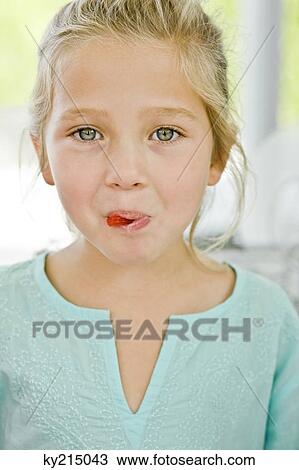 Portrait of a girl eating a candy View Large Photo Image Stock Image - Portrait of a girl eating a candy. Fotosearch