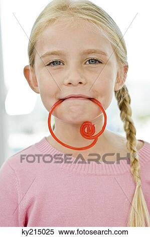 Portrait of a girl holding a candy in her mouth View Large Photo Image Stock Photography - Portrait of a girl holding a candy in her mouth. Fotosearch