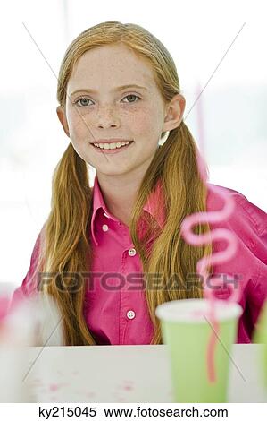 Stock Photography - Portrait of a girl smiling in a birthday party. Fotosearch