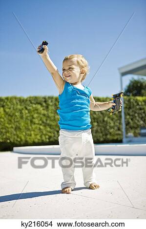 Baby boy holding a remote controlled car and smiling View Large Photo Image Picture - Baby boy holding a remote controlled car and smiling. Fotosearch