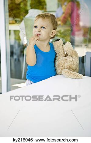Baby boy holding a teddy bear and looking up View Large Photo Image Stock Photograph - Baby boy holding a teddy bear and looking up. Fotosearch
