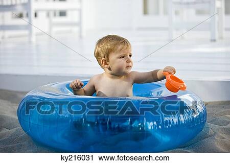 Baby boy sitting in an inflatable ring View Large Photo Image Stock Image - Baby boy sitting in an inflatable ring. Fotosearch