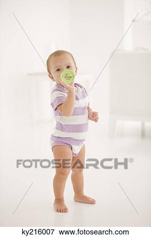Stock Photo - Baby girl drinking water from a baby bottle. Fotosearch