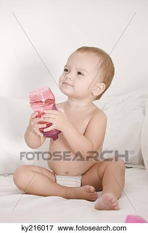 Baby girl holding a baby bottle View Large Photo Image Stock Photo - Baby girl holding a baby bottle. Fotosearch