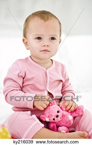 Baby girl holding a teddy bear View Large Photo Image Stock Photo - Baby girl holding a teddy bear. Fotosearch