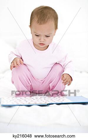 Baby girl looking at a picture book View Large Photo Image Stock Photo - Baby girl looking at a picture book. Fotosearch