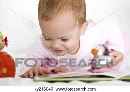 Baby girl looking at a picture book View Large Photo Image Stock Photo - Baby girl looking at a picture book. Fotosearch