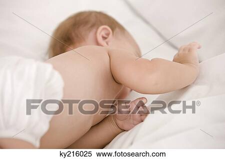 Baby girl lying on the bed View Large Photo Image Stock Photography - Baby girl lying on the bed. Fotosearch