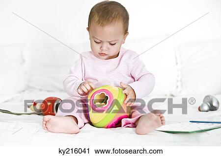 Baby girl playing with toys on the bed View Large Photo Image Stock Image - Baby girl playing with toys on the bed. Fotosearch