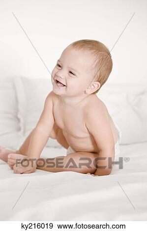 Close-up of a baby girl laughing on the bed View Large Photo Image Stock Photo - Close-up of a baby girl laughing on the bed. Fotosearch