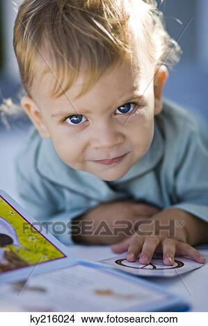 Portrait of a baby boy reading a picture book View Large Photo Image Picture - Portrait of a baby boy reading a picture book. Fotosearch