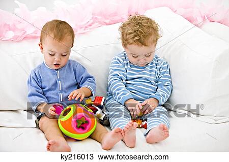 Two babies playing with toys View Large Photo Image Stock Image - Two babies playing with toys. Fotosearch